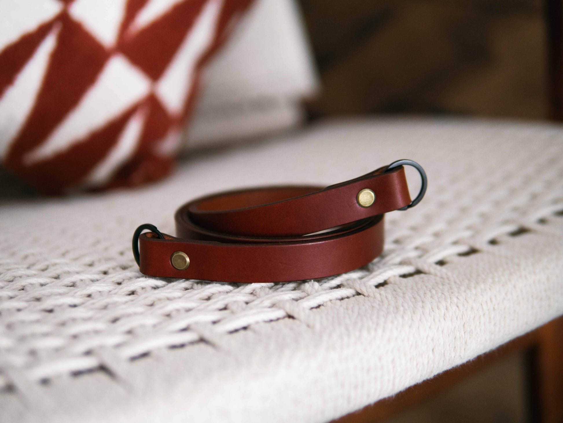 Brown leather belt on a textured surface with a blurred background
